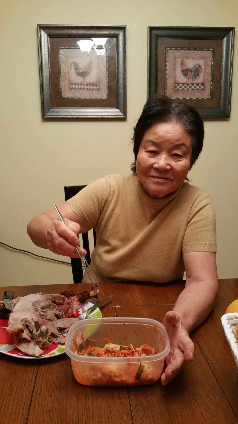 Mom at the dinner table after Thanksgiving 2015, with a plate of smoked turkey